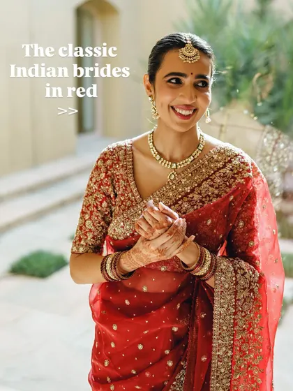 The classic Indian bride in red. Her happy, natural smile is the best accessory to her soft makeup and traditional red saree.
