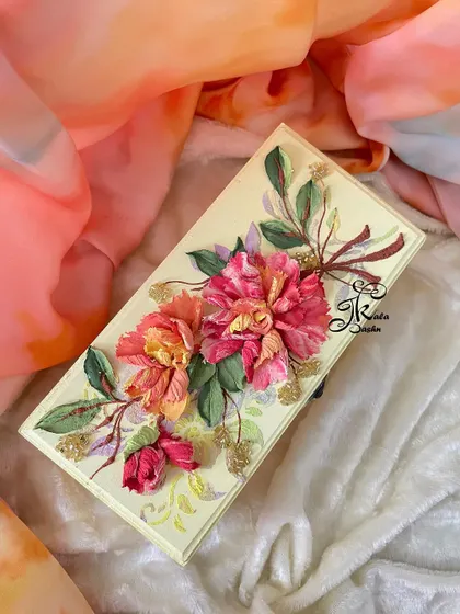 An elegant storage box with a soft yellow base, adorned with a beautiful bouquet of two-toned pink and yellow flowers.