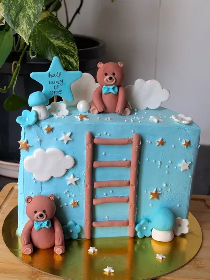 A "Halfway to One" cake for a six-month birthday. This adorable blue cake features teddy bears climbing a ladder towards the stars.