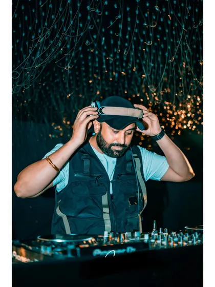 Adjusting my headphones to lock into the next track. This is a classic DJ pose, but it represents the constant focus required to blend songs perfectly.