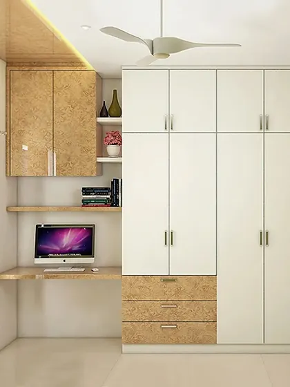 A compact bedroom design that cleverly integrates a study desk and a full-height wardrobe into one seamless unit. The use of white and light wood laminates makes the room feel larger and brighter.