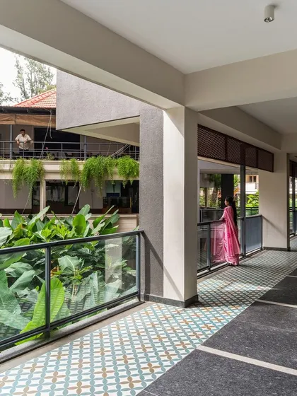 A view from a corridor in the Koramangala Club Annexe, looking across a lushly planted courtyard towards the older club building. Our design focused on creating visual connections and overlaps between the new and existing structures.