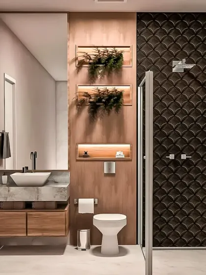 A nature-inspired bathroom design with a floating marble-top vanity and recessed wall niches with lighting for plants. The dark, textured shower tiles provide a dramatic contrast.
