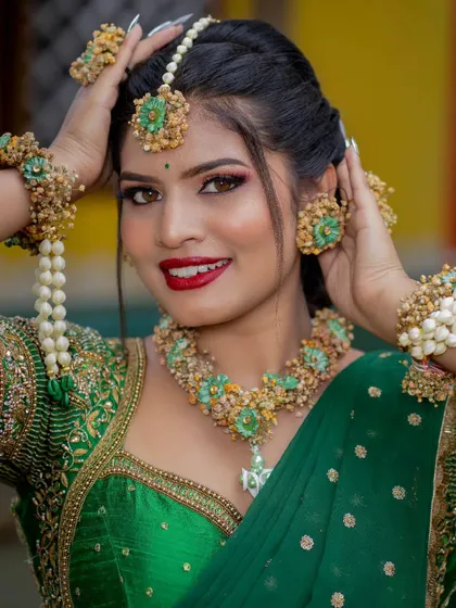 A vibrant Mehendi or Haldi look, featuring a green saree and beautiful floral jewelry. We teach students to create specific looks for every wedding function.