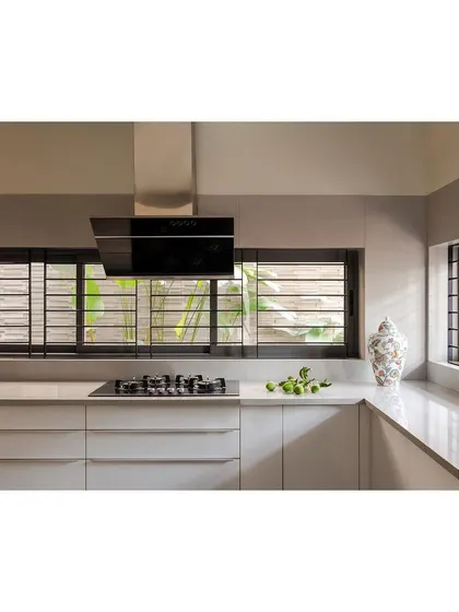 A modern kitchen design in the 'Solid Void Solid' house, featuring clean lines, handleless cabinetry, and ample natural light from the strip windows. The layout is optimized for functionality while maintaining a minimalist aesthetic that connects to the adjacent service court.