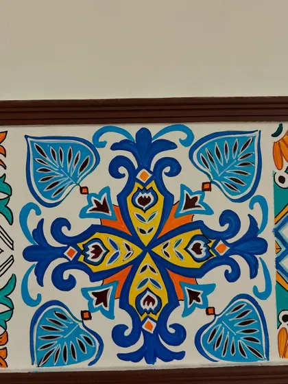 A close-up of another tile pattern from the Moroccan mural. The combination of blues, yellows, and oranges creates a warm and inviting feel, perfect for a personal space like a bedroom.