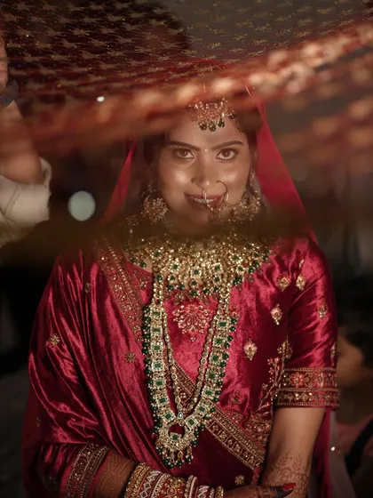 The moment she looks up. I love this shot because it shows the confidence in her eyes. Her traditional red lehenga and green jewelry are perfectly complemented by the classic bridal makeup.