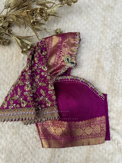 A rich purple blouse with heavy floral embroidery on the sleeves. The design uses multiple shades of thread to create depth and dimension.
