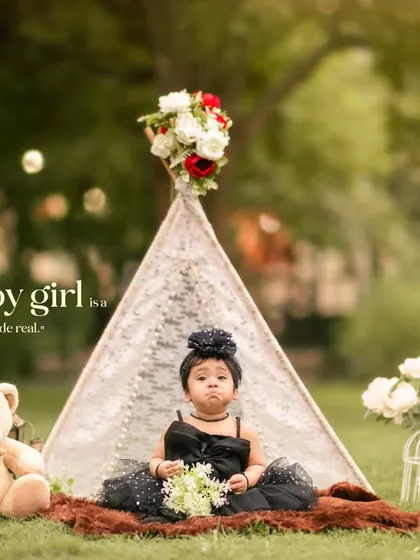 A dreamy bohemian-themed outdoor session featuring a little girl in a lace teepee, surrounded by a teddy bear and flowers. This setup is perfect for creating whimsical, storybook portraits.
