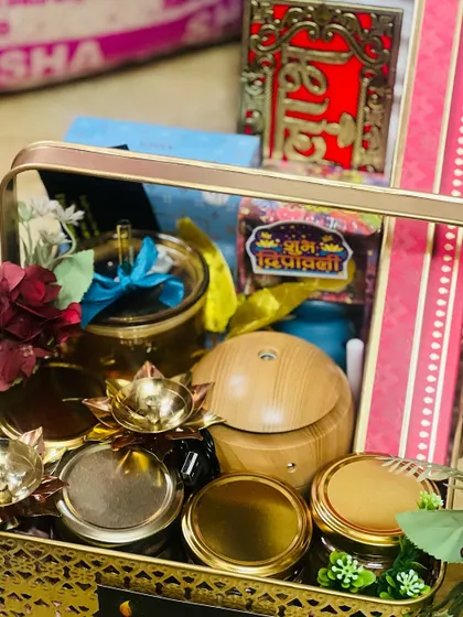 Another close-up of a Diwali basket, highlighting the aroma diffuser, brass diyas, and jars of festive treats.