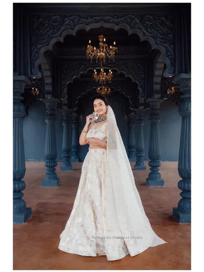 A full-length view of the off-white lehenga, showing its beautiful drape and the sheer dupatta.