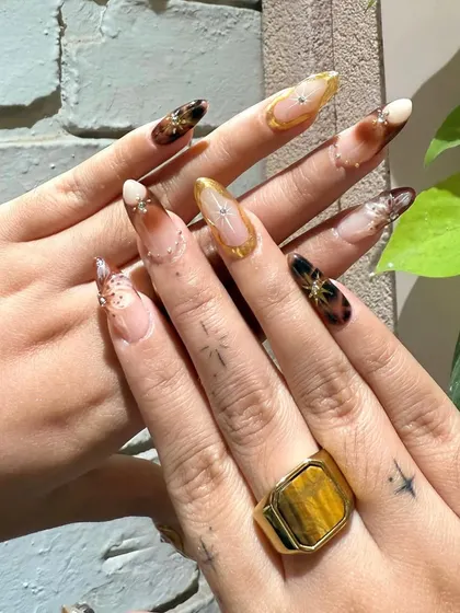 This angle shows off the client's own star tattoos, which we incorporated into the celestial theme of the nail art.