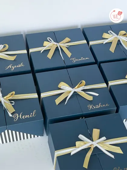 Elegant and uniform gift boxes for the entire groom's squad. These deep blue boxes are personalized with each groomsman's name in gold and tied with a beautiful ribbon.