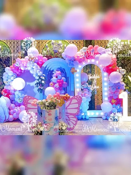 A breathtaking butterfly-themed stage in shades of blue and pink, featuring illuminated arches, floral arrangements, and glowing butterfly props.