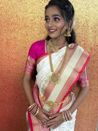 A beautiful, natural look for a bride in a white and pink saree. The makeup is soft and luminous, perfect for a daytime event.