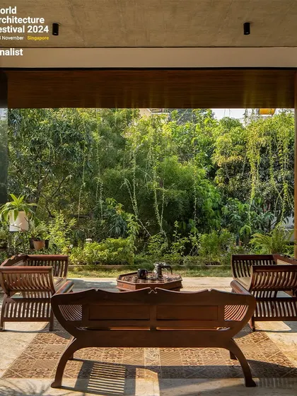 A close-up of the outdoor seating area, which acts as an extension of the living room. The furniture is crafted from wood, complementing the natural setting.