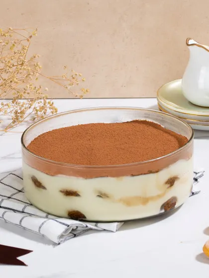 Our signature Tiramisu, presented in a large glass bowl. We use high-quality mascarpone and espresso-dipped Savoiardi biscuits to create this authentic and beloved dessert.