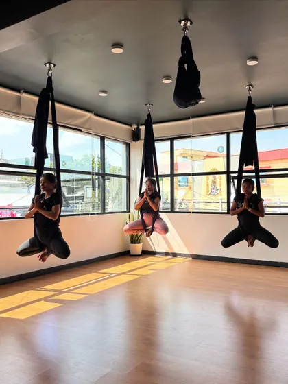 Three students meditate in unison while suspended in the air. This practice enhances focus and brings a unique sense of calm.