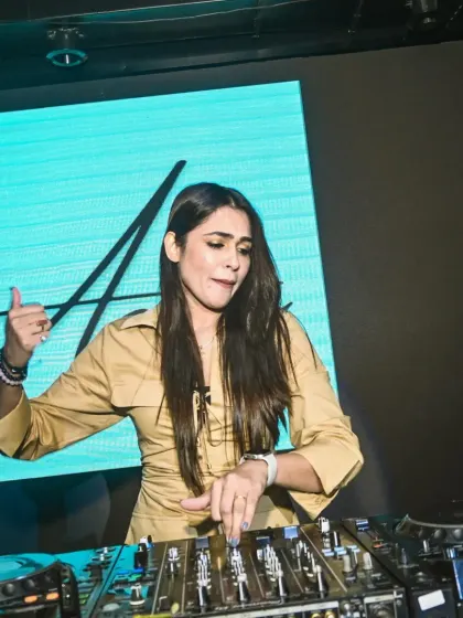 Pointing to the crowd while mixing, with my signature logo on the screen behind me. It's a gesture of connection, telling the audience "this beat is for you."