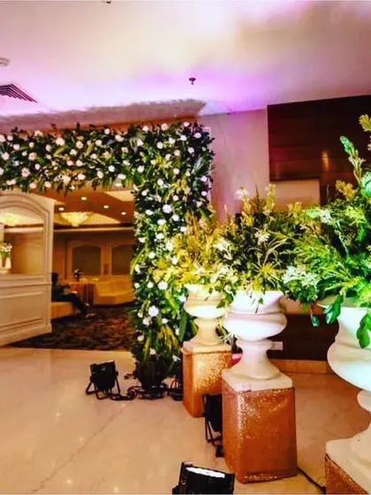 A lush and inviting entrance I created for a wedding reception. The doorway is framed by a dense arch of white flowers and fresh greenery, setting a tone of elegance right from the moment guests arrive.