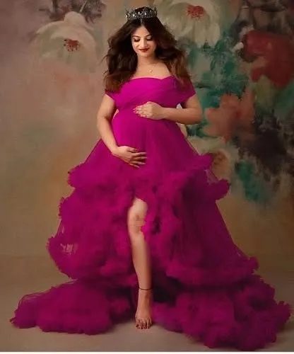 A client wearing a crown with our magenta ruffled gown. The high slit and dramatic tulle skirt create a bold and confident look, perfect for a studio photoshoot.