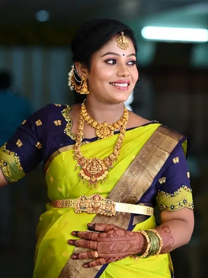 A radiant mom-to-be at her seemantham ceremony. Her hands are adorned with traditional mehendi that complements her beautiful silk saree and temple jewelry.