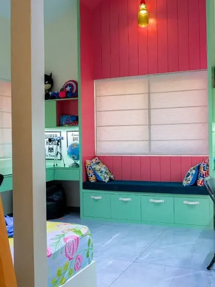 This kids’ room is a wonderland of colors, featuring a bunk bed, a cozy window seat with storage, and dedicated study desks for both play and focus.