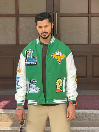 A close-up of the varsity jacket, focusing on the patches and design details.