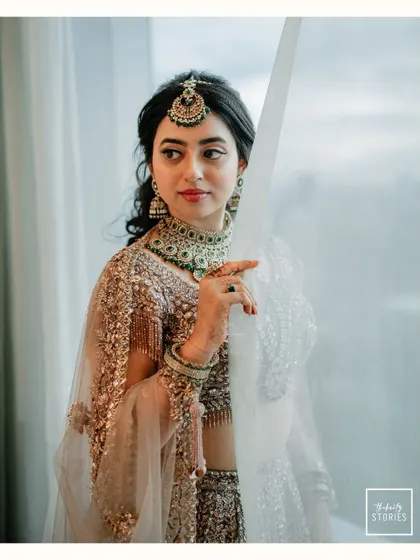 A stunning portrait of the bride by a window, her thoughtful gaze and exquisite sequined lehenga creating a picture of modern elegance.