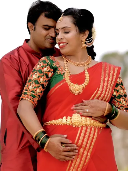 A close-up of the maternity look, showing the soft eye makeup and traditional hair accessories. The client is wearing a classic red saree for her seemantha.