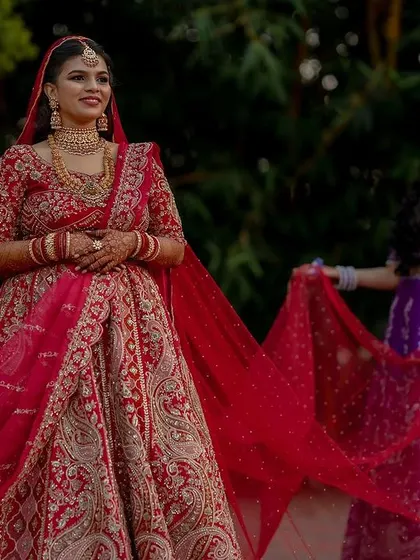 A regal bride in her magnificent red lehenga. We capture the grandeur of the bridal attire, creating portraits that are both powerful and elegant.