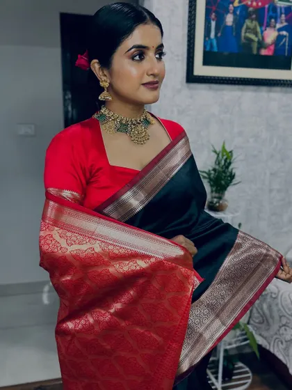 A full view of this elegant retro-inspired look. The makeup, with its defined eyes and deep lip color, pairs beautifully with the classic black saree and traditional gold jewelry for a powerful statement.