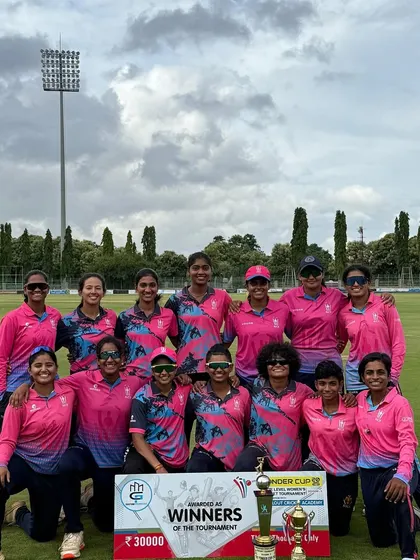 The NICE Devils with the winner's banner and trophy in Mysore. A picture of consistency and dominance in women's state-level cricket.