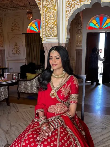 Aashna wanted a look that felt like her, just elevated. We kept her skin looking fresh and natural, a perfect canvas for her classic red lehenga.