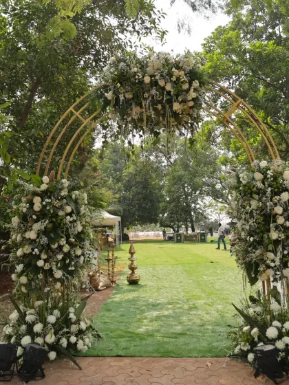 A direct view of the stunning white floral arch, creating a beautiful gateway for guests entering the garden ceremony.