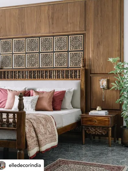The parents' bedroom in the 'Brihati' project is a deep dive into Chettinad character. The bed wall is clad in veneer with tin tiles as a backdrop, and the custom bed features intricate carving. It’s a space rich in texture and traditional motifs.