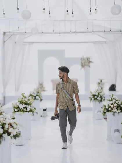 A behind-the-scenes shot of me, the photographer, at work in a beautifully decorated wedding venue. This shows my presence and perspective on the day.