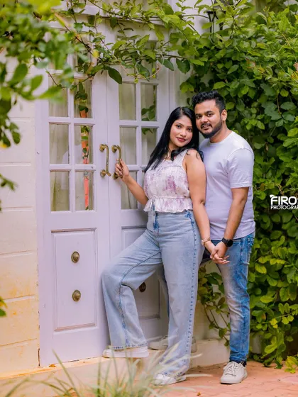 A cute and casual pose by a white country-style door. The couple's coordinated casual outfits and the charming backdrop make for a sweet and modern portrait.
