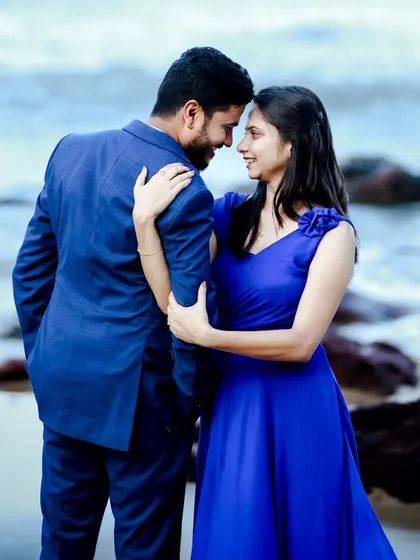 A classic romantic pose on the beach. The royal blue of her gown and his suit creates a powerful and elegant look against the soft colors of the sea.
