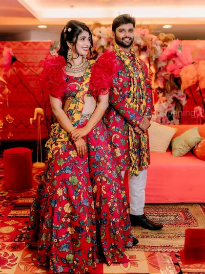 A candid moment from the Mehendi ceremony. The couple's coordinated floral outfits look perfect against the colorful and eclectic decor we designed.