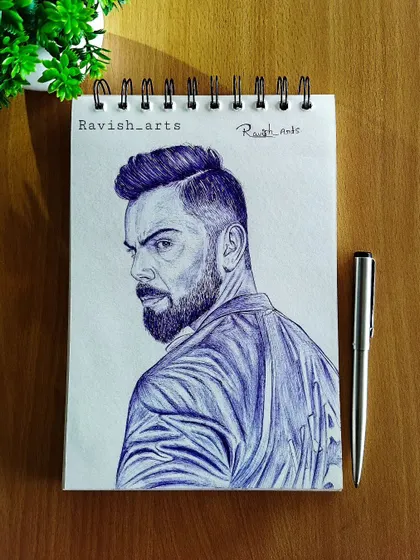 A finished ballpoint pen portrait of Virat Kohli, created to celebrate his 76th century. The blue ink gives it a distinct and striking look.