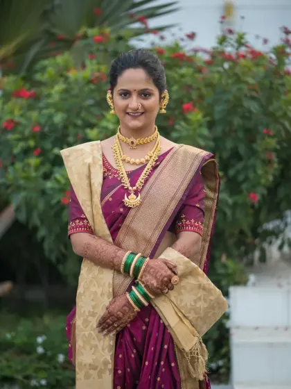 A radiant bride in a traditional purple and gold saree, her hands adorned with my intricate mehendi. This photo shows how the henna beautifully complements a classic bridal look.