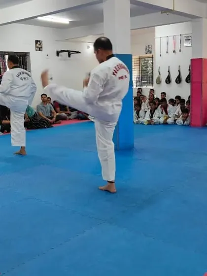 Two senior students demonstrating a front kick.
