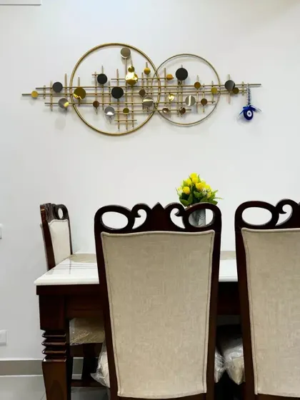 A close-up of a dining area with a beautiful metal wall art piece, demonstrating how we use decor to add personality and a focal point to a room.