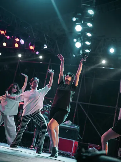 Dancers in motion during the sound check, with dramatic lighting highlighting their movements.