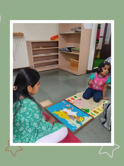 Manvitha demonstrates her knowledge of geography with a map puzzle. Her mother watches proudly as she identifies different parts of the world.