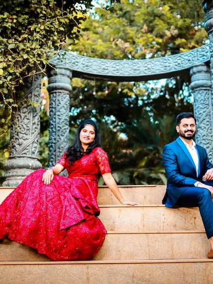 A relaxed and happy moment from their pre-wedding shoot. The red lace gown and blue suit look great against the natural, earthy backdrop.