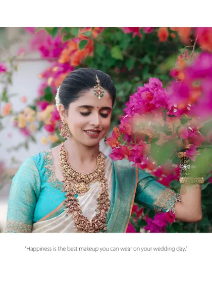 "Happiness is the best makeup you can wear on your wedding day." This candid shot of the bride smiling amidst bougainvillea flowers perfectly captures that sentiment.