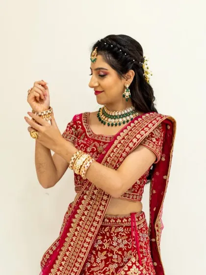 A side profile of the bride, showing her elegant braided hairstyle and the flawless application of her makeup.