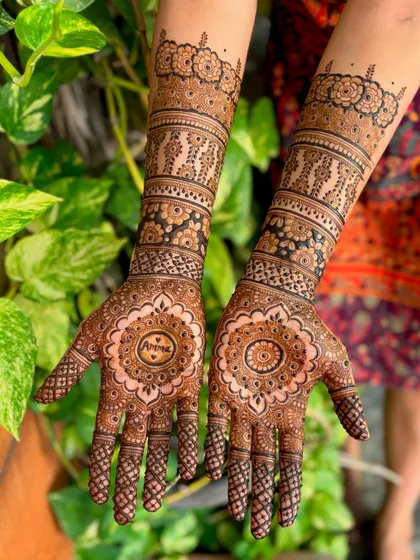 A beautiful bridal mehendi with a central mandala incorporating the groom's name, "Arvind."